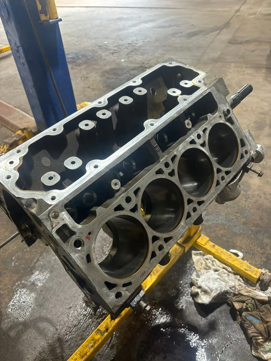 Bare V-configuration engine block on a stand with the cylinder bores open and empty, at AutoNorth Auto Repair in North Bay