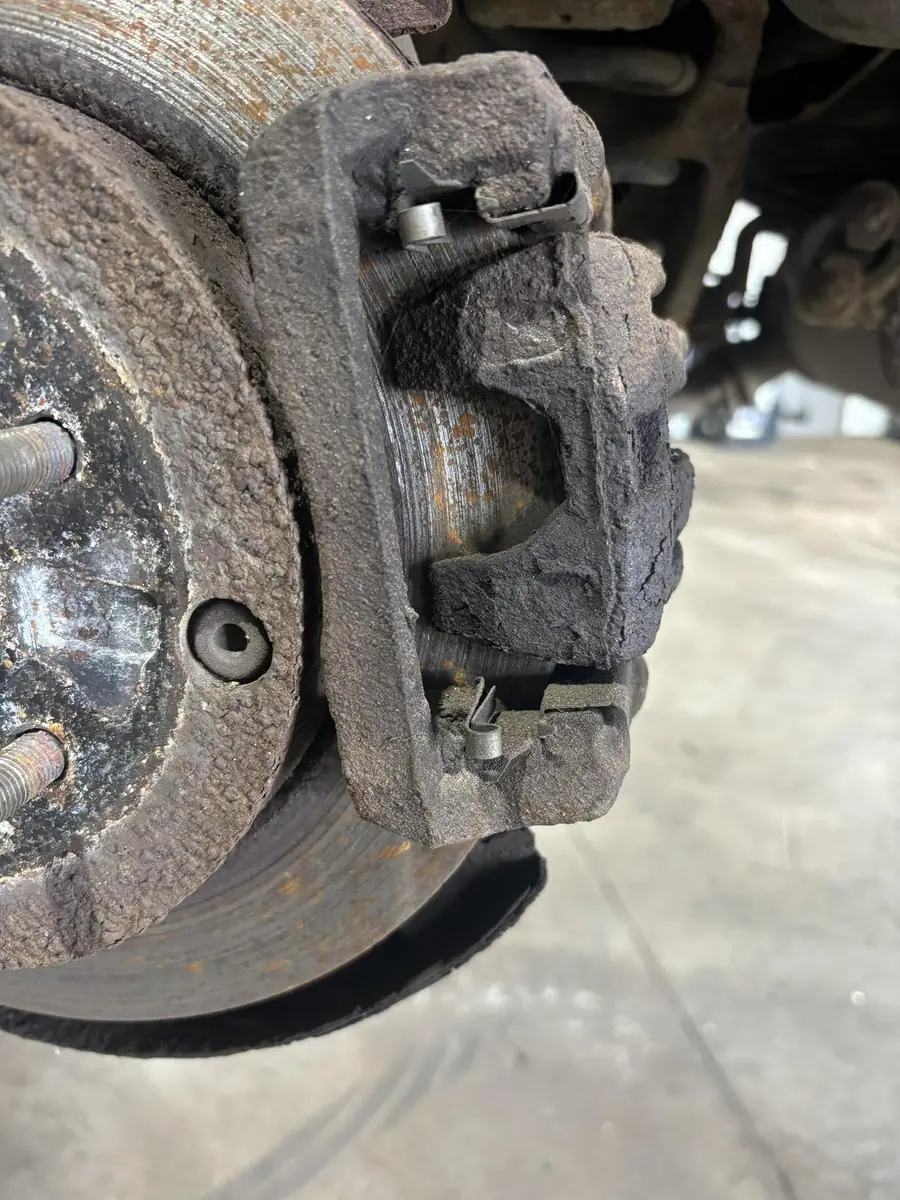 Heavily corroded brake caliper and rotor on a vehicle at AutoNorth Auto Repair in North Bay